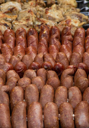 Sausages are roasted on the grill in the open air. Sausages are traditionally prepared at all gastronomic festivals. Very hearty and tasty dish. Street picture of food.の写真素材