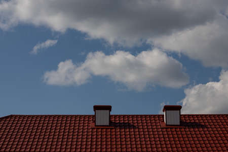 chimney on the roof of the house against the blue sky.の写真素材