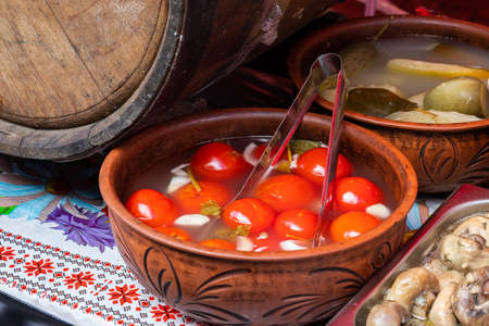 Salted tomatoes on a ceramic brown plate.の写真素材