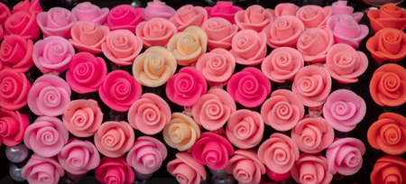 Beautiful colors of plastic Rose and Lilly flower bouquet with different flowers. Decorative colorful Floral wall background.の写真素材