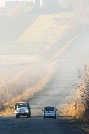 Car on the road in the fog. Autumn landscape.の写真素材