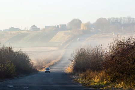 Car on the road in the fog. Autumn landscape.の写真素材