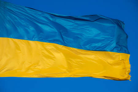 Ukrainian flag in the wind. Against the background of the sky.