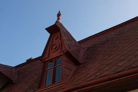 The roof of the house is made of red metal tiles, a beautiful large chimney.