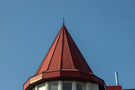 The roof of the house is made of red metal tiles, a beautiful large chimney.の写真素材