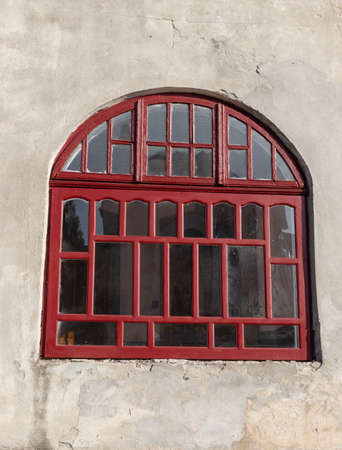 An old vintage wooden window with peeling paint oh frames needed to be repaired or replaced.