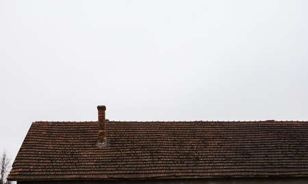 The roof of the house is made of red metal tiles, a beautiful large chimney.の写真素材