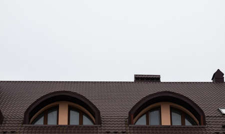 The roof of the house is made of red metal tiles, a beautiful large chimney.の写真素材