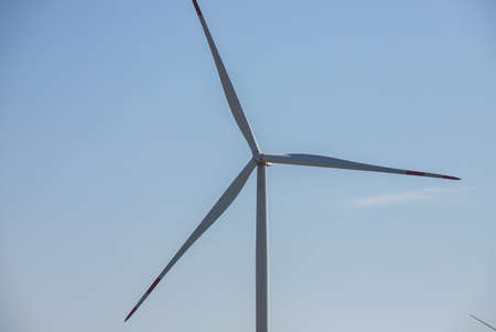wind mill or also wind-turbine on wind farm in rotation to generate electricity energy on outdoor...
