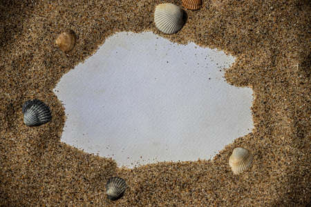 Blank white sheet of paper on white sand with seashells and stones. Message by the sea, romance, valentine's day, mother's day, father's day. copyspace.の写真素材