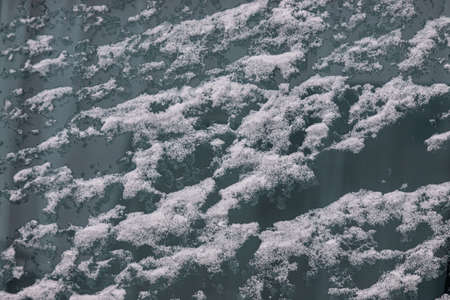 Beautiful winter background with snowy ground. natural snow texture. Wind sculpted patterns on snow surface.の写真素材