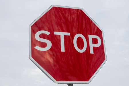 roadside red stop sign on a cloudy background. sign isolated.の写真素材