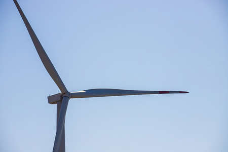 wind mill or also wind-turbine on wind farm in rotation to generate electricity energy on outdoor with sun and blue sky, conservation and sustainable energy concept.の写真素材