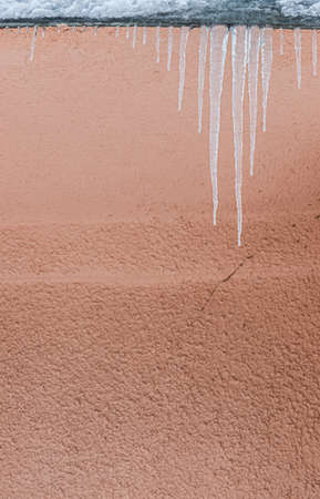 Icicles on the roof. The drain is full of snow and ice. Icicles falling danger concept.の写真素材