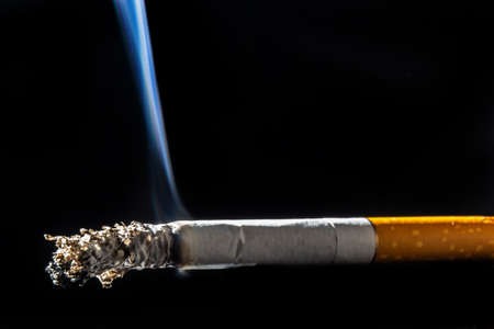 Cigarette smoking closeup isolated on balck background. no smoking concept.の写真素材