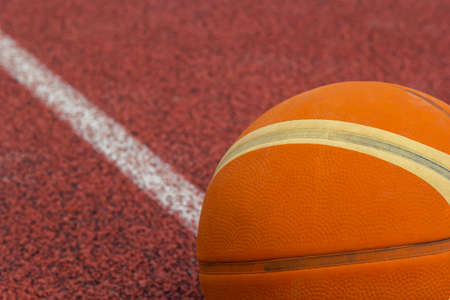 Orange ball for basketball lying on the sport court.Sport red court outdoor .Copy space.Top view.の写真素材