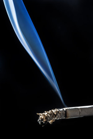 Cigarette smoking closeup isolated on balck background. no smoking concept.の写真素材