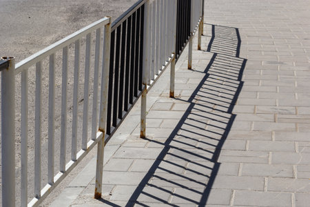 Handrail by road. Pedestrian barrier. Fence along road. Fencing details.