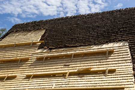 Roof construction site. Removal of old roof, replacement with new shingles, equipment and repair. Roofs are a very important part of all housing projects around the world.の写真素材
