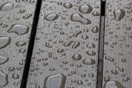 wet wooden planks of bench, background of wood texture with water drops from the rain, autumn mood.の写真素材