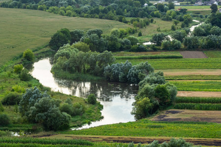 Sunny summer landscape with river.Green hills and meadows.の写真素材