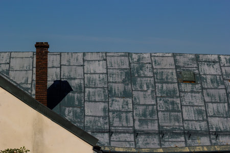 Metal roof of a detached house and chimney against the sky, metal roof tiles, gutters.
