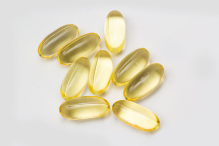 Fish oil capsules omega 3 on light background. Transparent yellow capsules of fish oil.