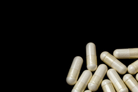 White capsules, pills on a black background with place for text. Medicine, healthcare concept. Range of pharmaceutical drugs.の写真素材