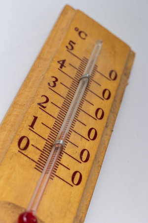 room thermometer on a wooden base close up on a white background. Celsius degree scale.
