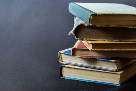 Stack of hardcover old books with an open book on a dark background. Bookshelf shop, Knowledge publications, literature. bookish bookstore bookstore.の写真素材