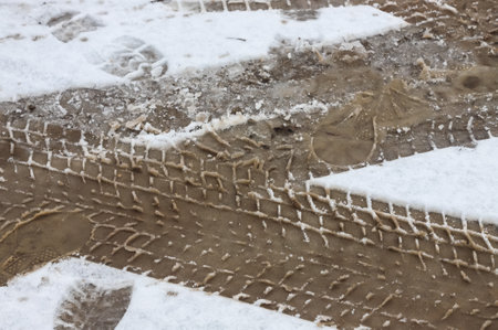 Car tracks on a snowy road. Slippery road, danger, risk of skidding. Traces of winter tire threads.の写真素材