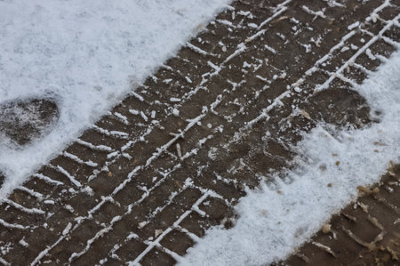 Car tracks on a snowy road. Slippery road, danger, risk of skidding. Traces of winter tire threads.の写真素材