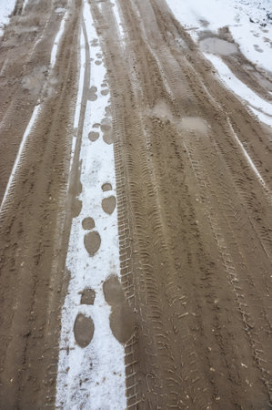 Car tracks on a snowy road. Slippery road, danger, risk of skidding. Traces of winter tire threads.の写真素材
