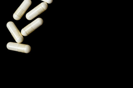 White capsules, pills on a black background with place for text. Medicine, healthcare concept. Range of pharmaceutical drugs.の写真素材