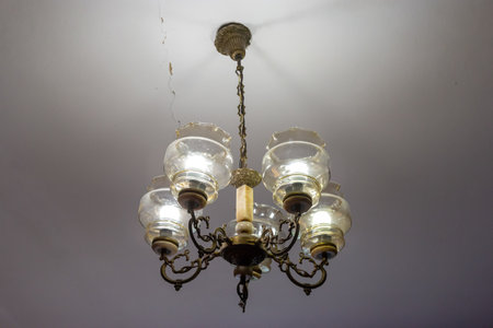 A beautifully crafted chandelier featuring six glass lanterns hangs from the ceiling, casting a warm...
