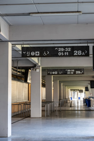 An open corridor in a public building features directional signs indicating restroom locations and accessible routes while maintaining a clean, organized look.の写真素材