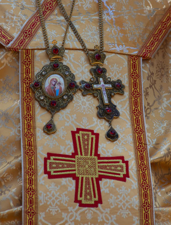 Intricate religious symbols in gold and red adorn a ceremonial vestment, highlighting the craftsmanship and spiritual significance within a sacred context.の写真素材