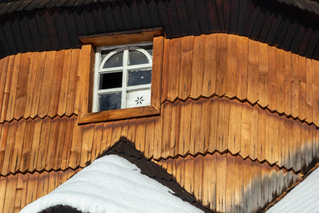 A close-up view of a wooden house featuring detailed craftsmanship, surrounded by snow, highlighting the beauty of traditional architecture in winter.の写真素材