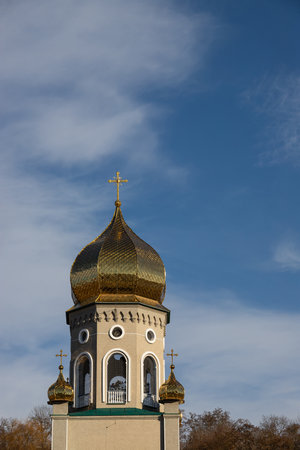 The golden dome of a church shines brightly under a clear blue sky, showing intricate architecture...