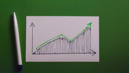 Paper graph shows an upward trend with peaks highlighted, drawn in black and green, placed beside a white pen on a vibrant green background during daytime.の素材