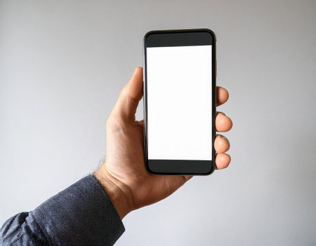 A user holds a smartphone with a blank screen in their right hand, highlighting the device's design and potential for various applications.の素材