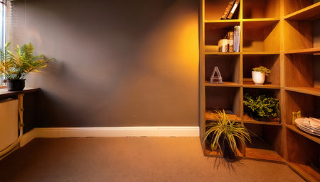 Interior of an office space featuring a well-decorated wall, wooden shelving units, and greenery creating a welcoming atmosphere.の素材