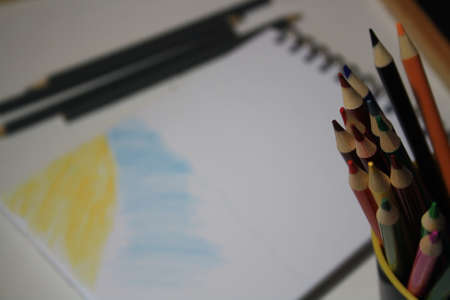 Notebook blank page, colorful pencils. Background with copy spaceの写真素材