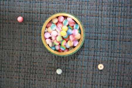 Colored decorative beads on a glass saucer. Top view