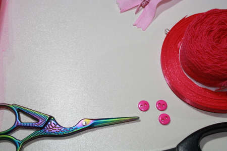 Sewing accessories and fabric close-up. Pink cloth