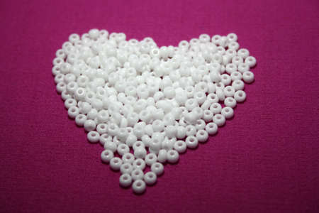 White beads spread on pink background. Space for text.の写真素材