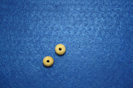 Wooden beads spread on blue background. Space for text.の写真素材