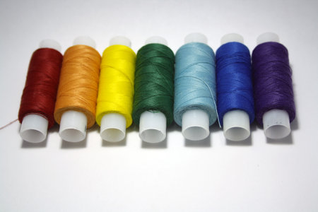Colorful yarn on spool, cotton. Colorful sewing threads on white background. Space for text.