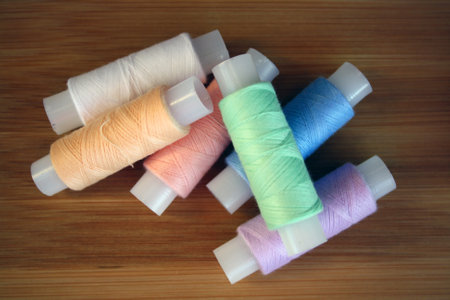 Colorful yarn on spool, cotton. Colorful sewing threads on white background. Space for text.