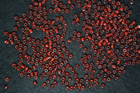 Red beads on a black felt background. Space for text.の写真素材